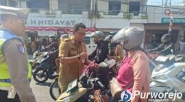 Aksi pembagian bendera Merah Putih yang dilakukan Badan Kesatuan Bangsa dan Politik (Kesbangpol) Kabupaten Purworejo kepada masyarakat, Selasa (11/8/2026).